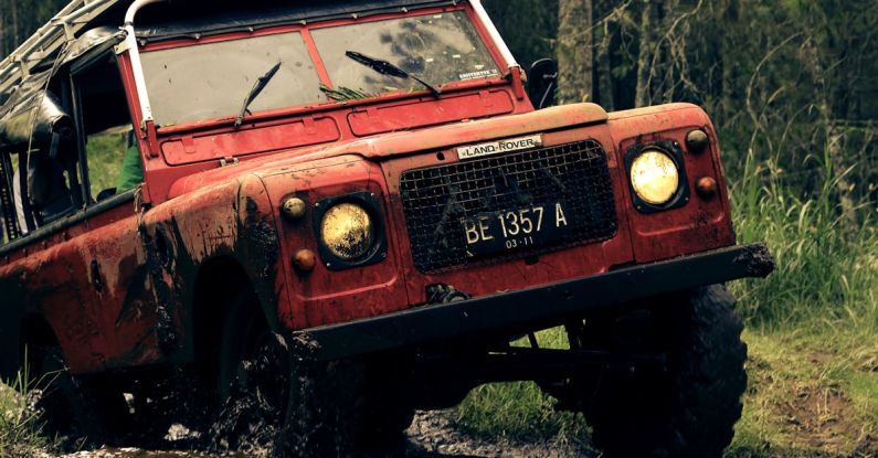 Ride - Red Car on Muddy Road Near Trees